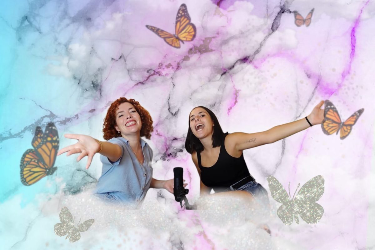 Mercè y su hermana, con los brazos abiertos y sonriendo, rodeadas de mariposas y nubes de colores, con un micrófono delante